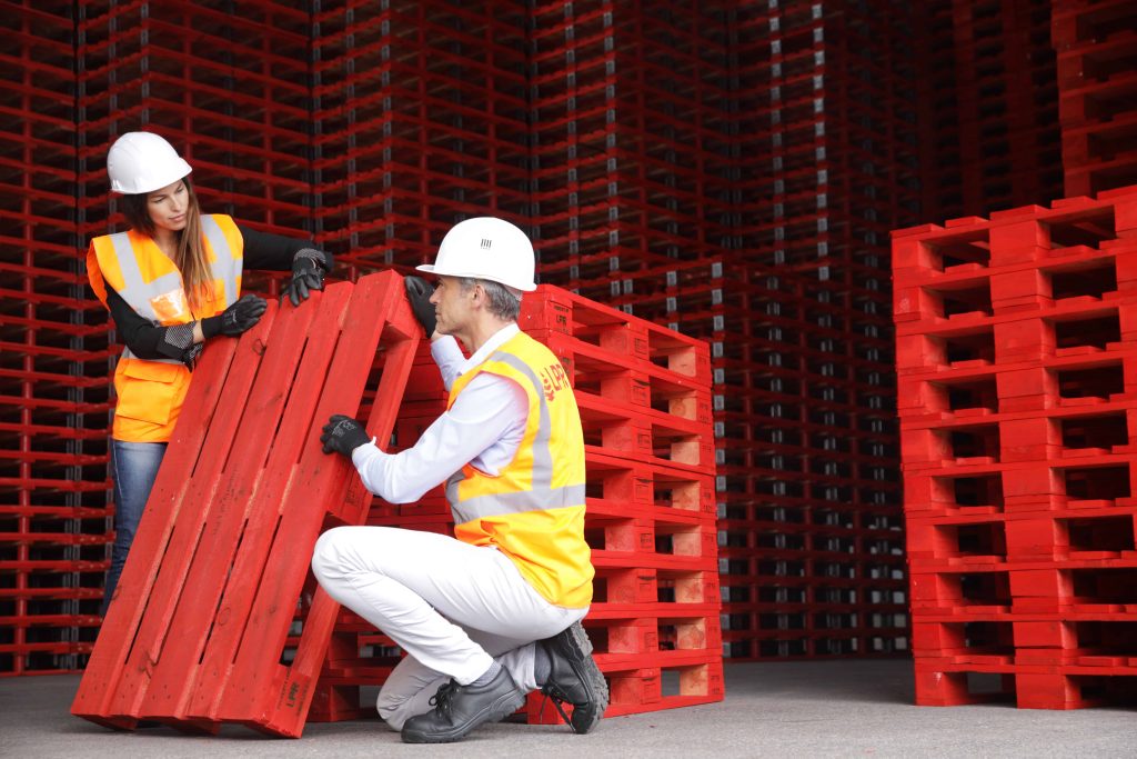 Pallet stacks with signs reading rent a pallet and buy pallets